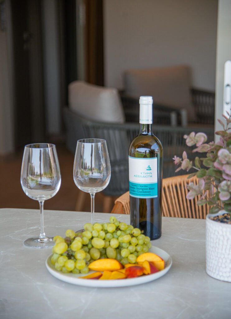 wine bottle, glasses and fruit on table